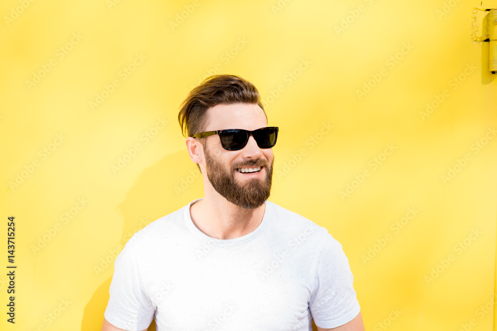 Colorful portrait of a handsome man dressed in white t-shirt on the yellow background