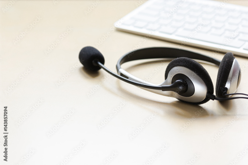 Office desk with headset and keyboard brown background mockup