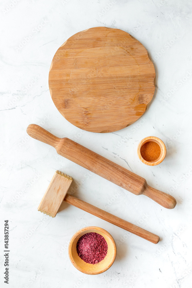 Cook workplace with kitchen tools, rolling-pin and spices white background top view