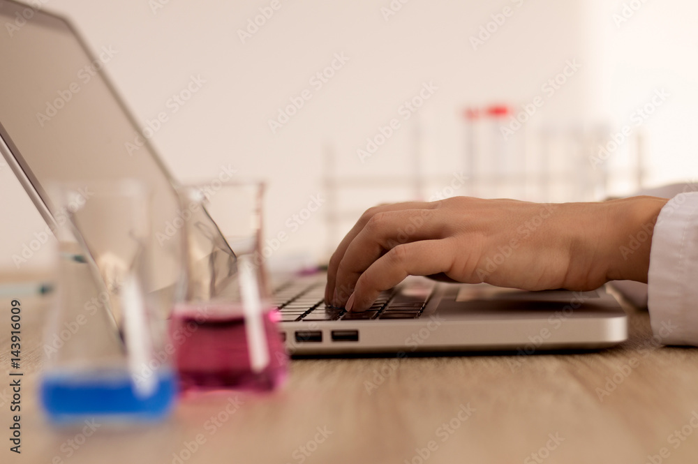 Medical researcher typing on laptop keyboard