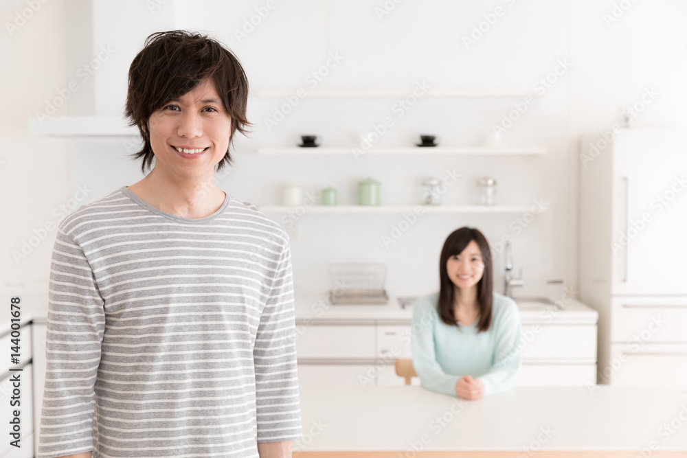 portrait of young asian couple relaxing in kitchen