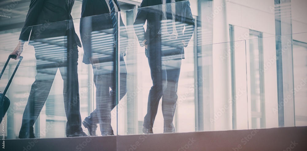 Businessman talking with colleagues while walking