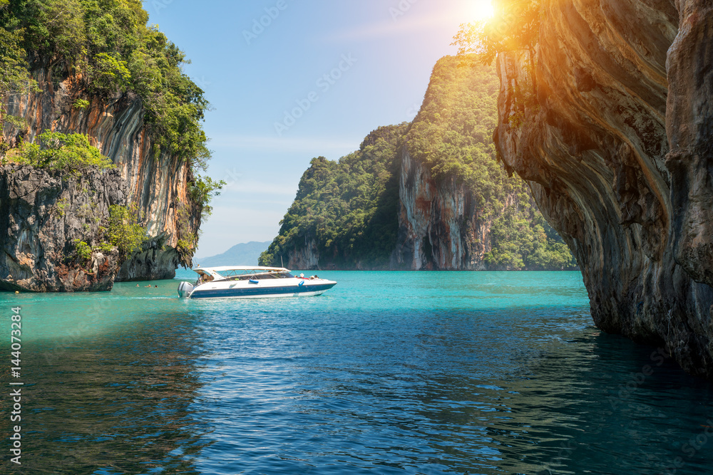 Beautiful landscape of rocks mountain and crystal clear sea with speed boat at Phuket, Thailand. Sum