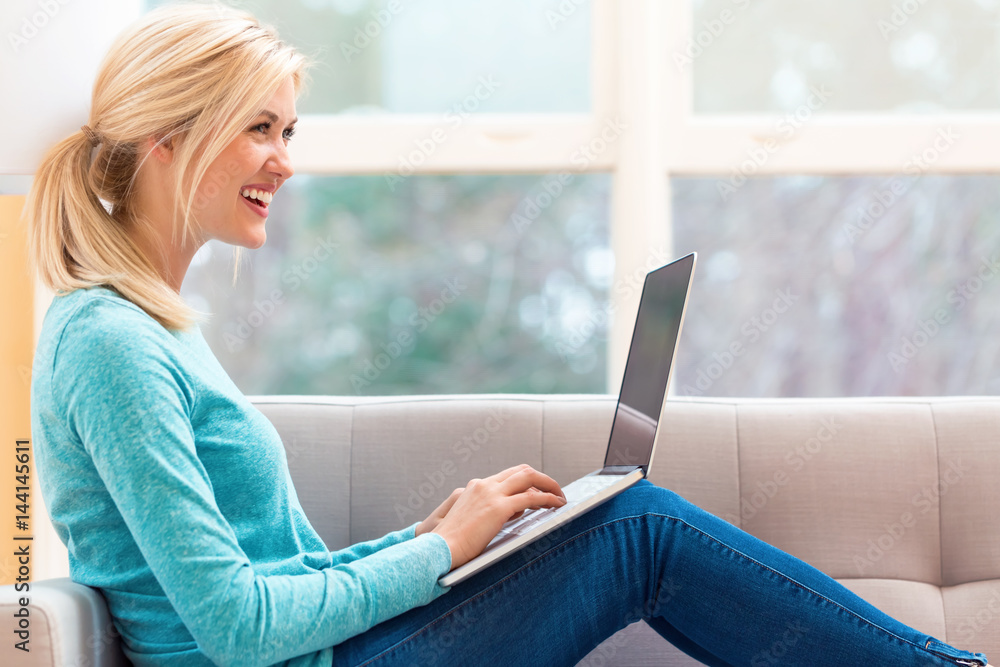 Happy young woman using her laptop