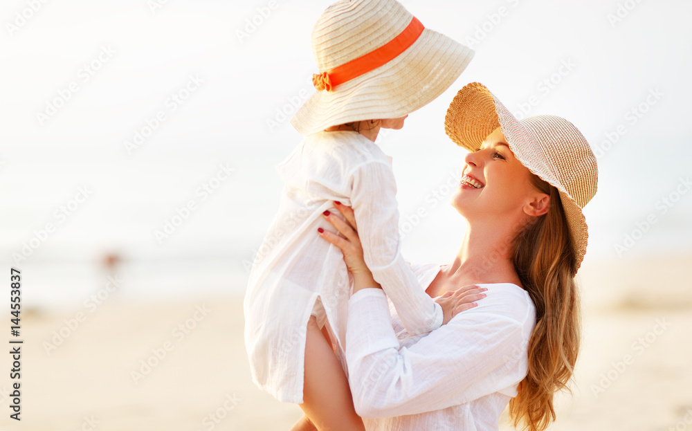 happy family at beach. mother and child daughter hug at sunset