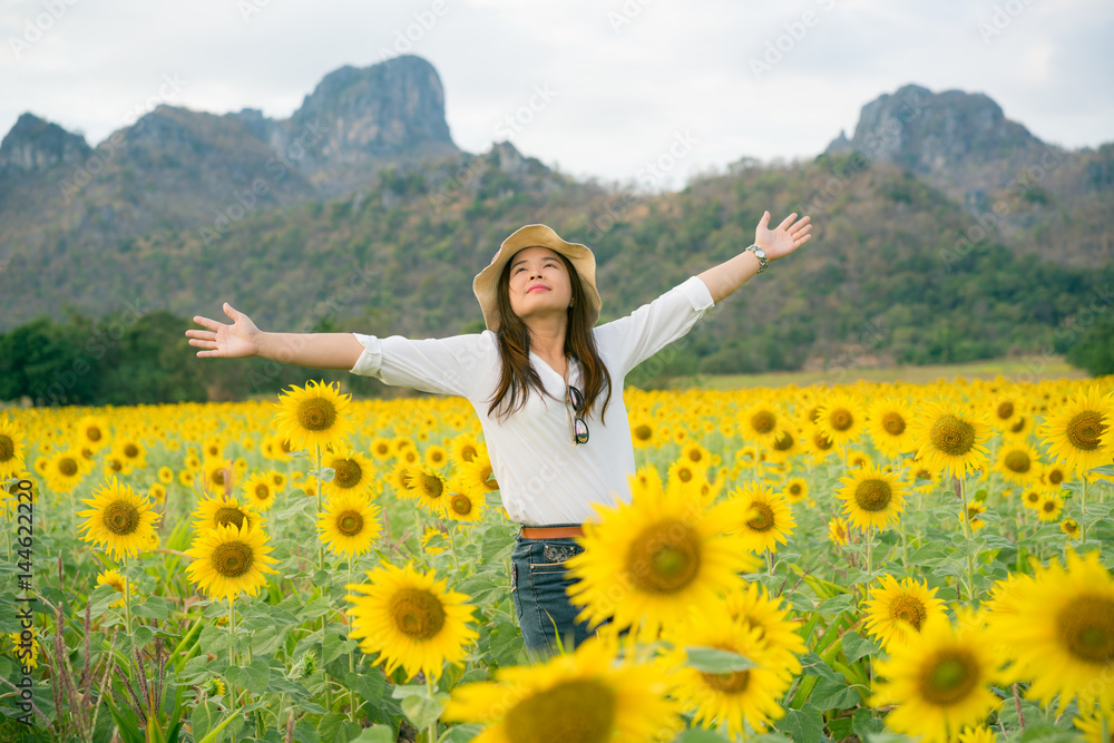 Woman in sunflower field. Healthy food product.