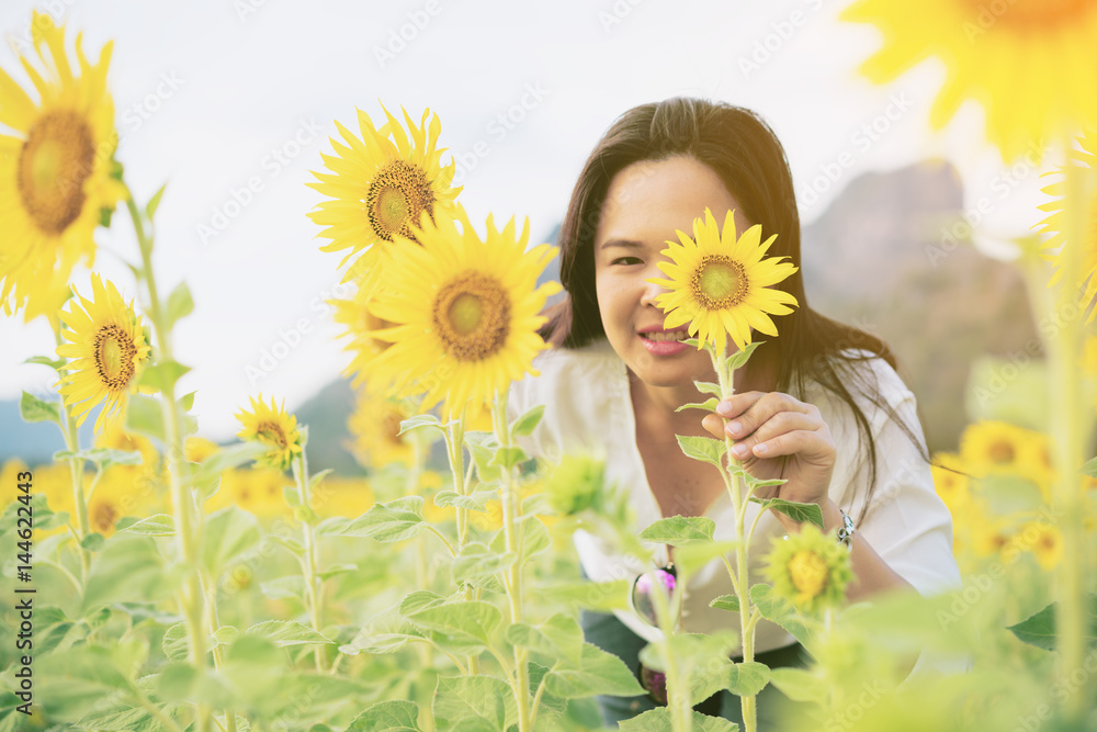 Sunflower and a woman hiding behind it