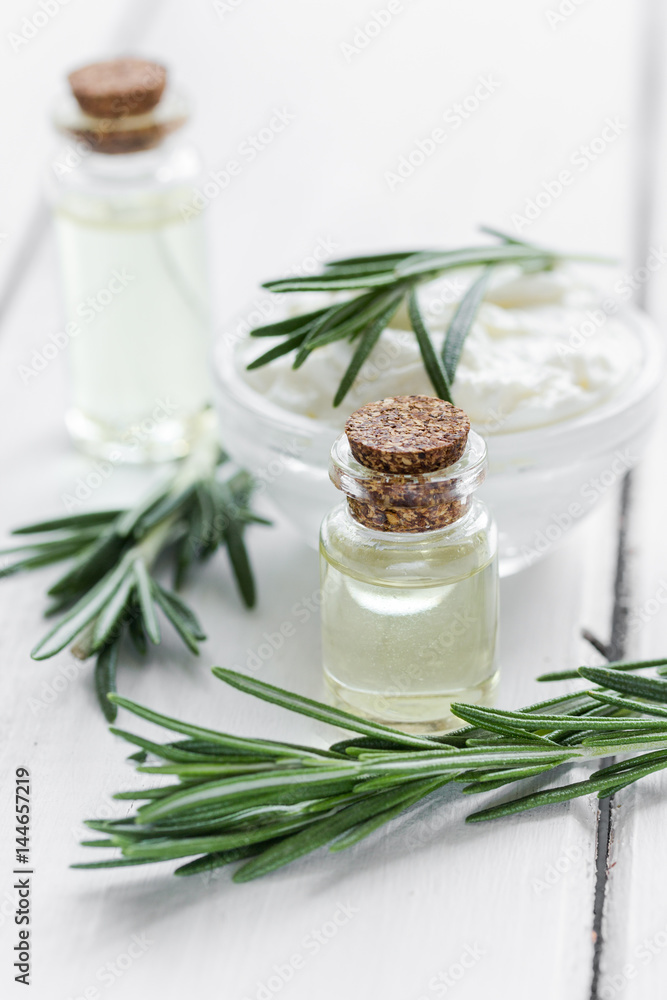 close up body care rosemary cosmetic products on white wooden desk background