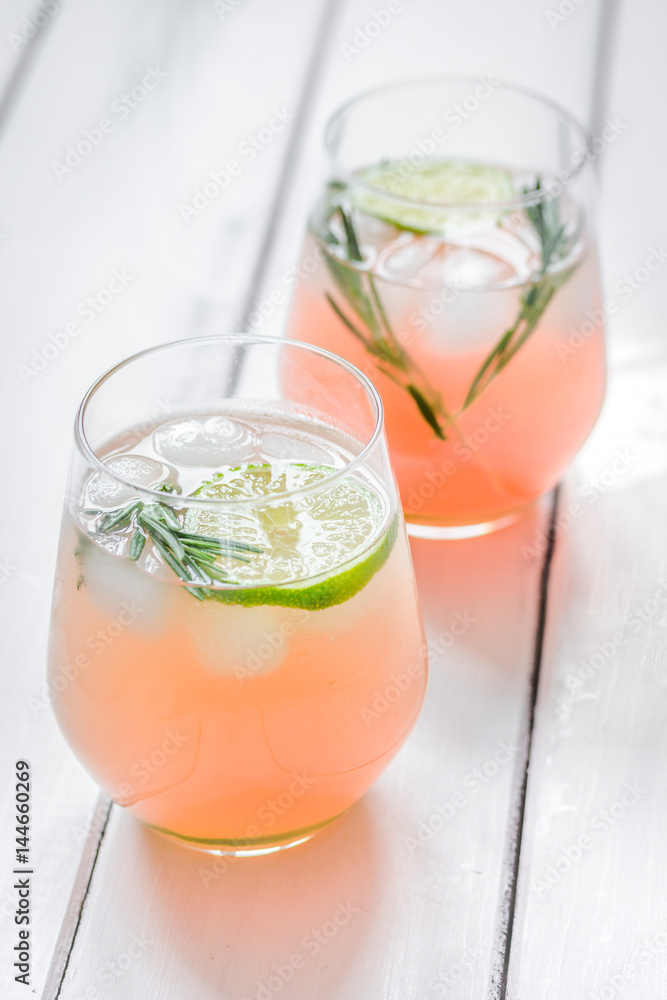 fitness cocktail in glass with lime and rosemary on white table background