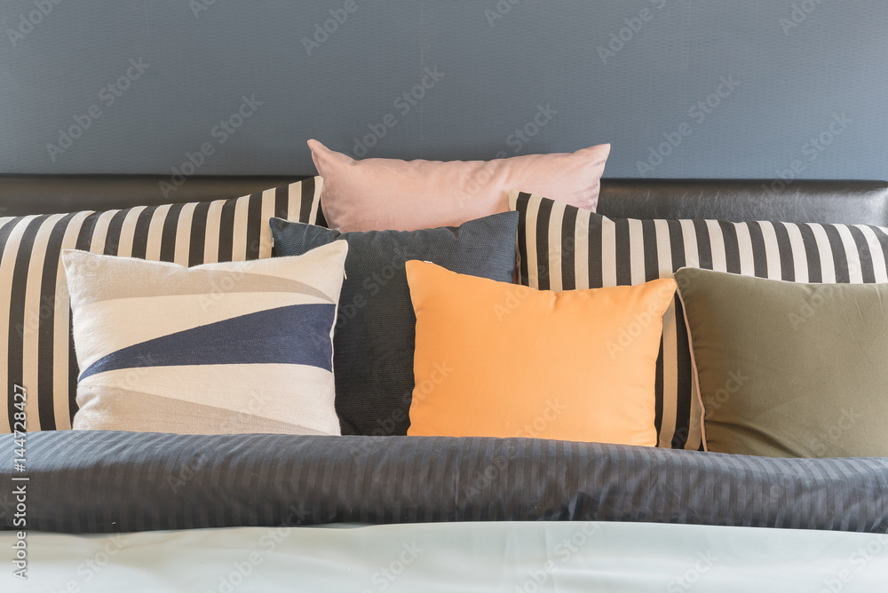 set of pillows on bed with blanket in blue bedroom