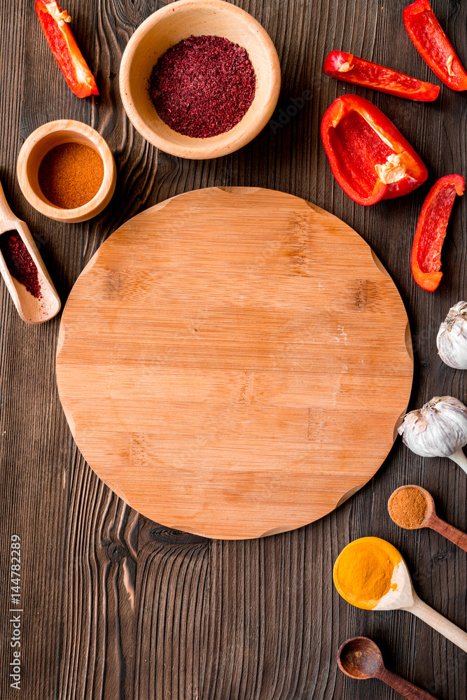 Professional kitchen with spices for cook on wooden background top view