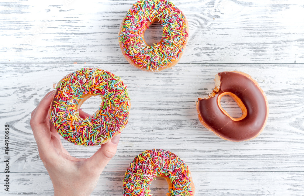 donuts and hand on wooden table background top view