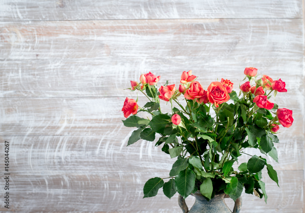 rose composition in vase with fresh flowers on wall background mock up