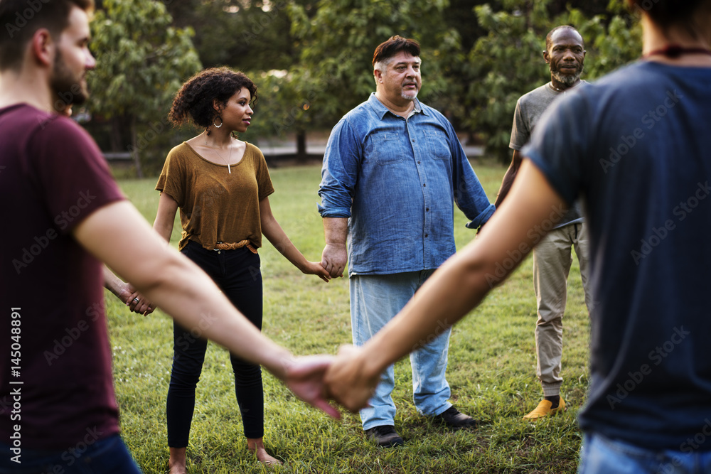 Group of people holding hand together in the park