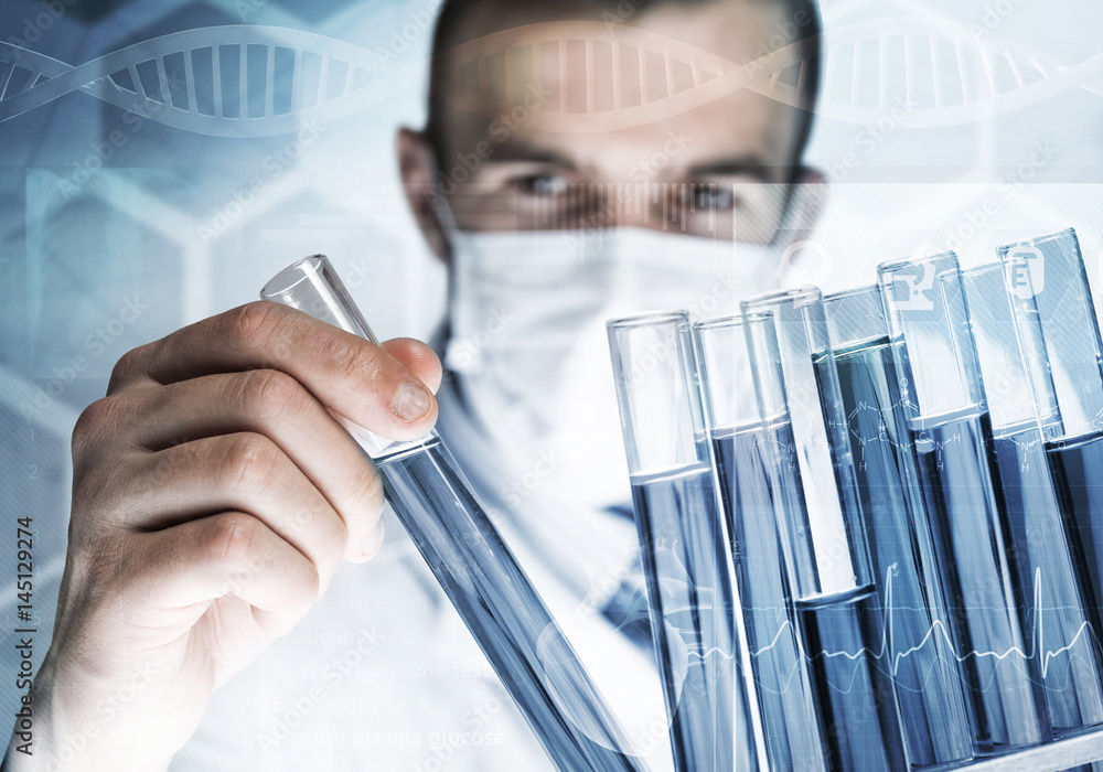 Portrait of concentrated male scientist working with reagents in laboratory