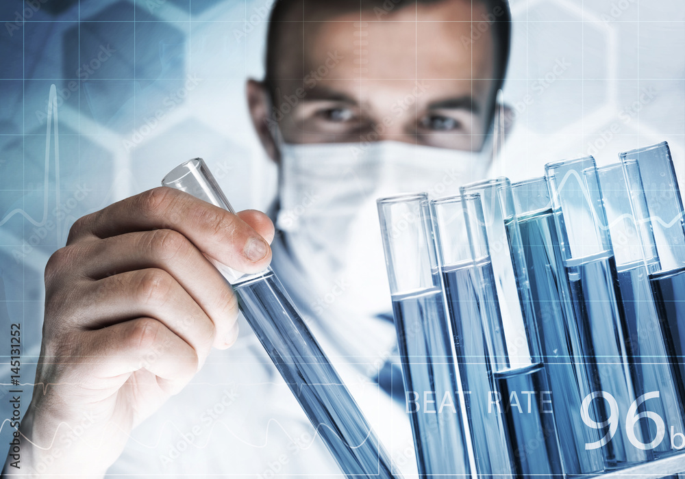 Portrait of concentrated male scientist working with reagents in laboratory