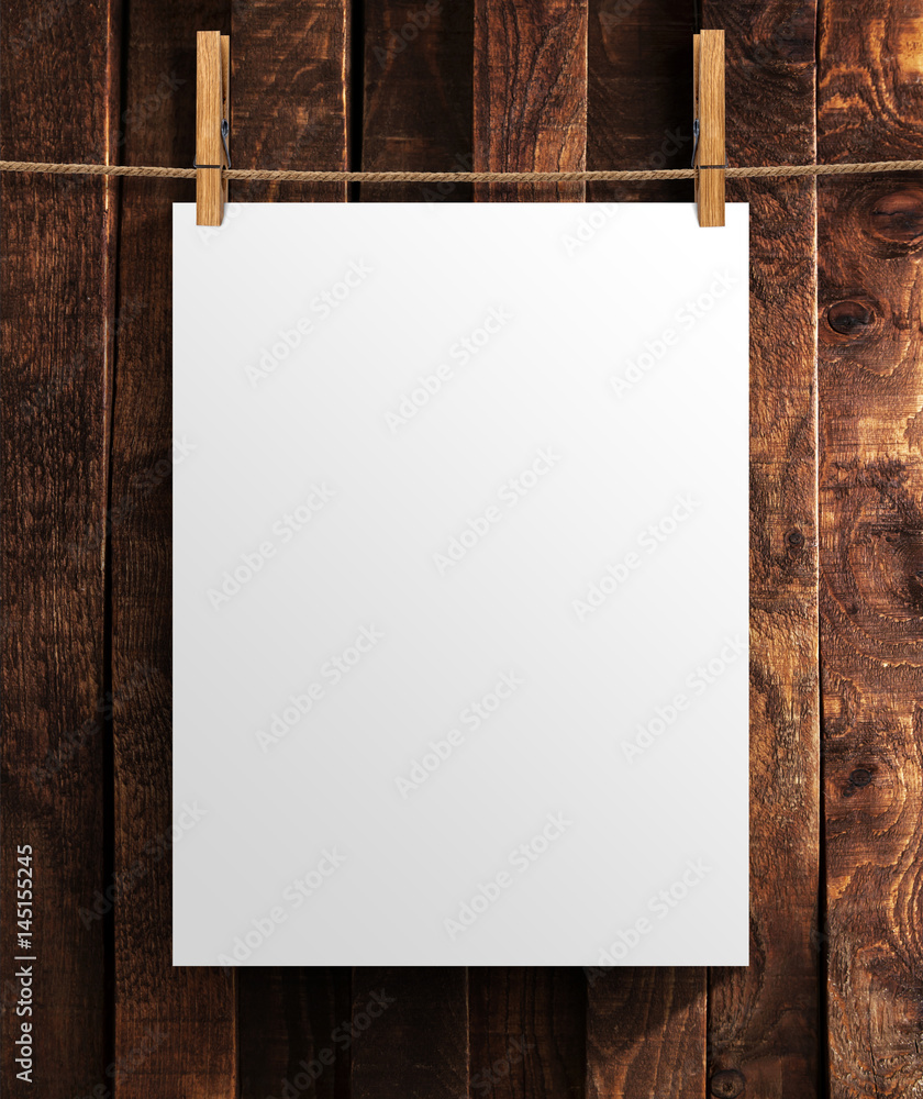 White poster on wooden background. Mock up for your project with copy space