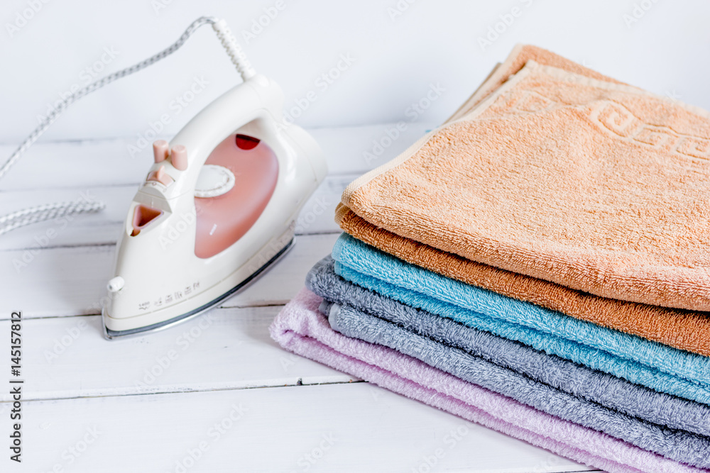 Bath towels stack with iron in laundry light background