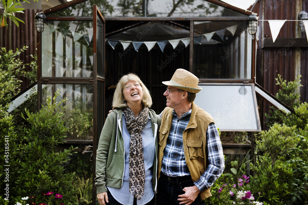 Senior couple planting vegetables at garden backyard