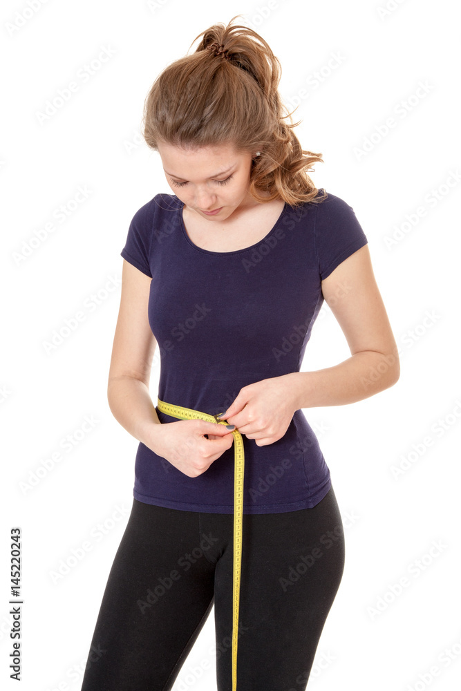 Young woman in sports wear holding measuring tape