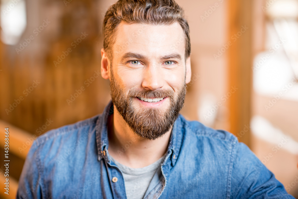 Close-up portrait of a handsome businessman or farmer indoors in the barn