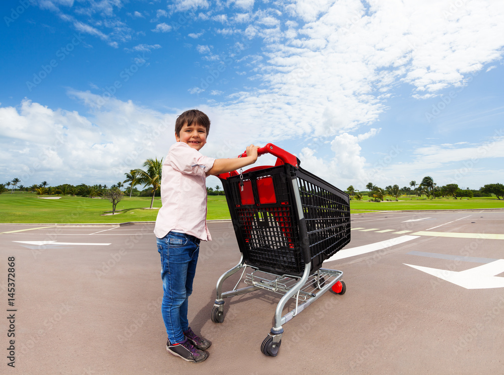 Little helper pushing supermarket shopping cart