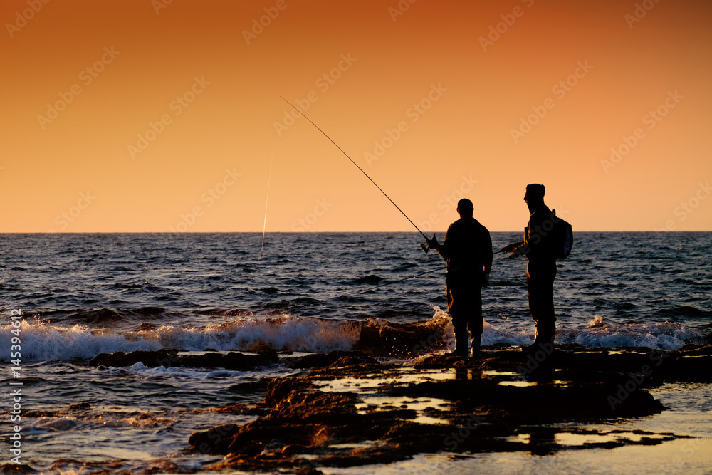 father and son fishing at sunset