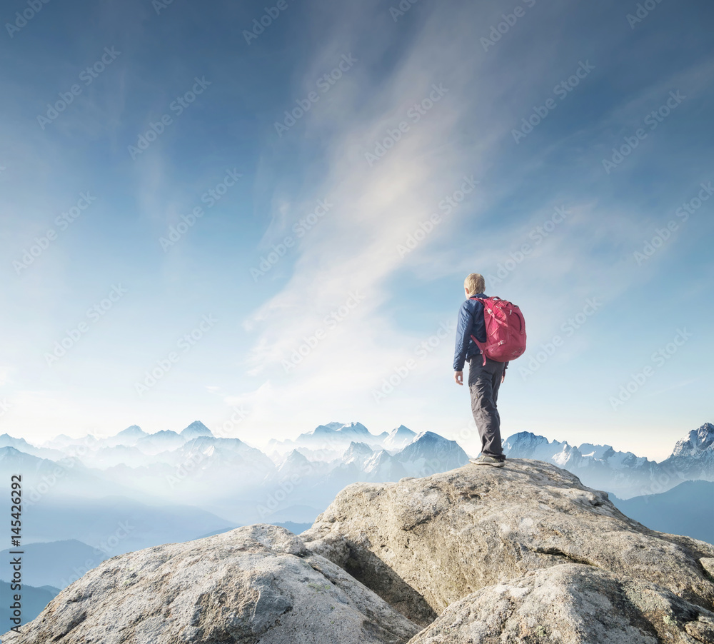 Tourist on the peak of high rocks. Sport and active life concept.