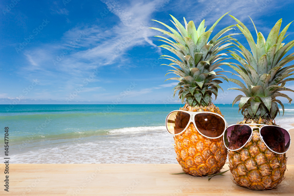 pineapple with sunglasses on wood,concept summer background.