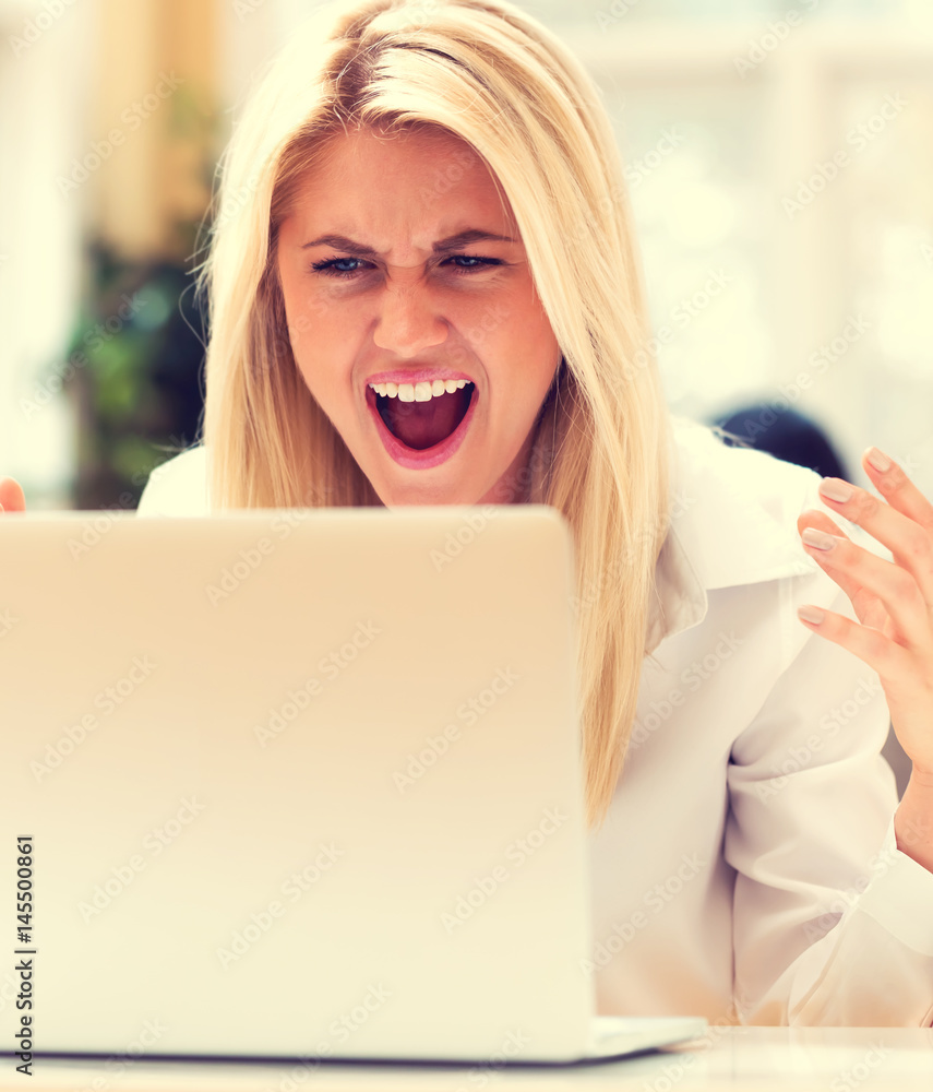 Unhappy young woman sitting at her desk