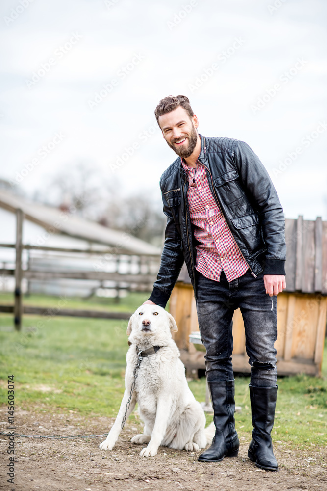 Stylish man with dog outdoors at the household