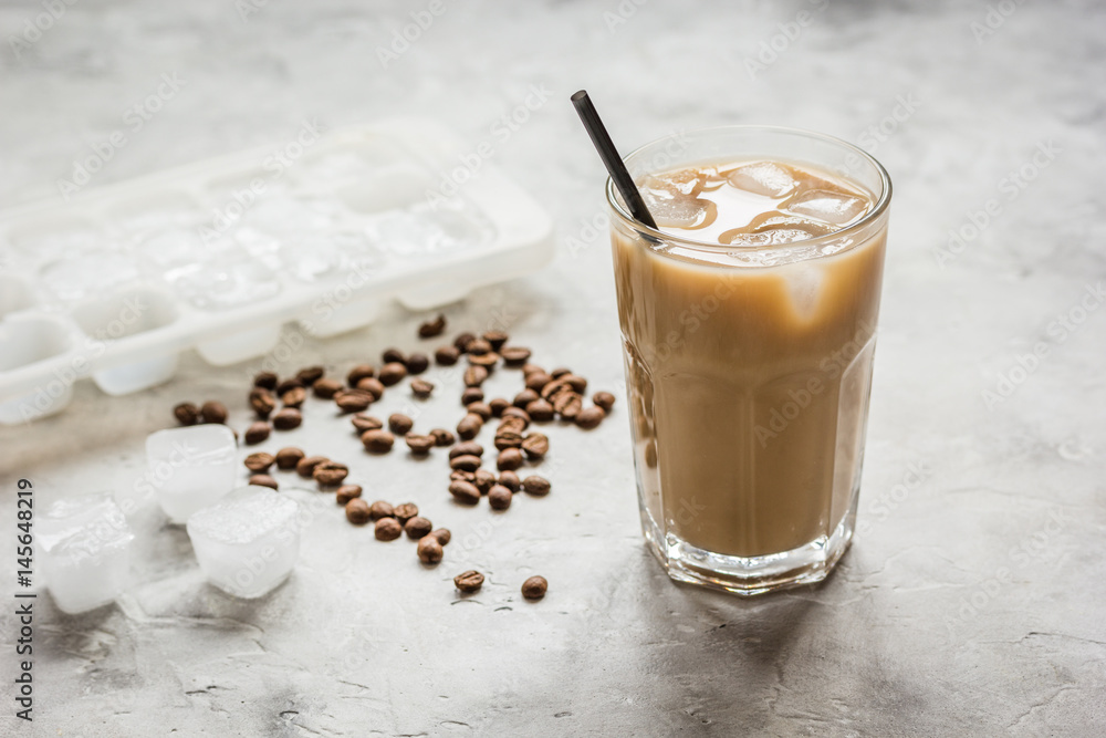 iced coffee with beans for cold summer drink on stone background