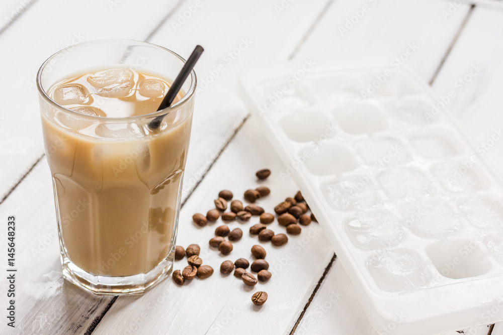 coffee break with cold iced latte and beans on white table background