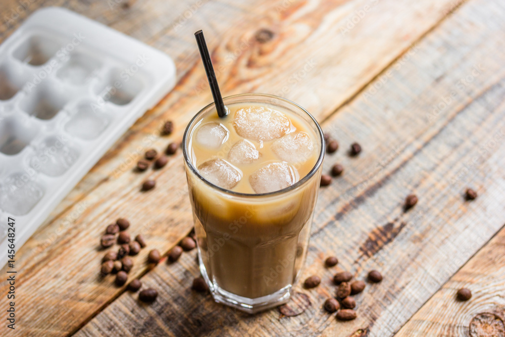 iced coffee with beans for cold summer drink on wooden background