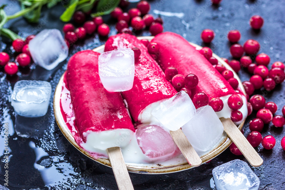 frozen cowberry and fruit ice-cream on dark table background