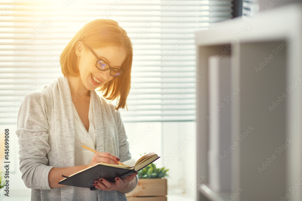 Happy businesswoman teacher with notebook