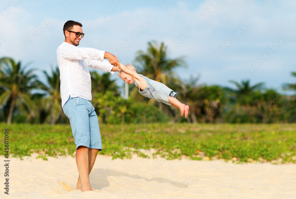 happy family father turns baby son on beach