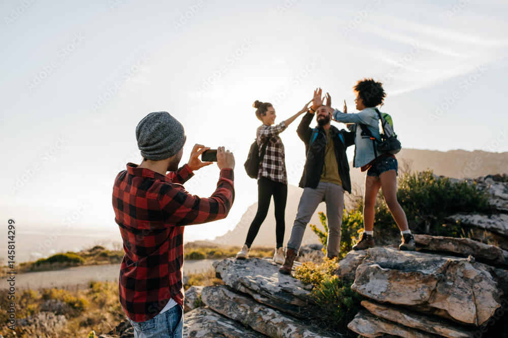 年轻人给朋友徒步旅行拍照