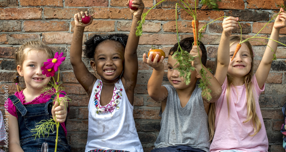 Group of kindergarten kids learning gardening outdoors