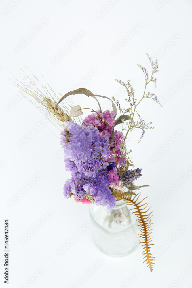 Dried flowers in a bottle isolated on white background