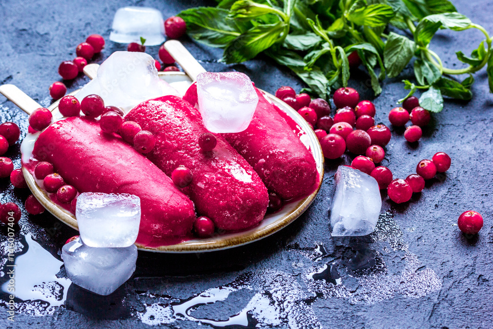 red berries with ice-cream on dark desk background