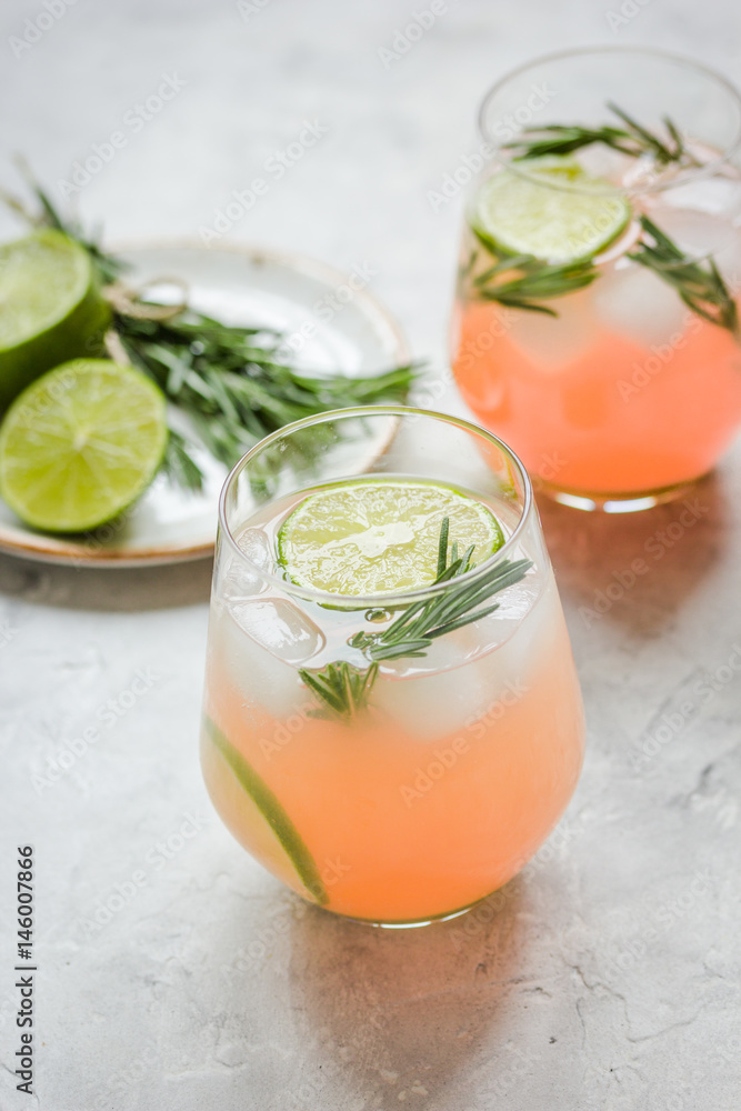 vegetable smoothie with lime and rosemary in glass on stone table background