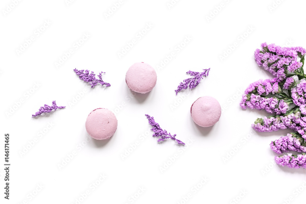 macaroons and flowers for light breakfast white desk background top view mockup