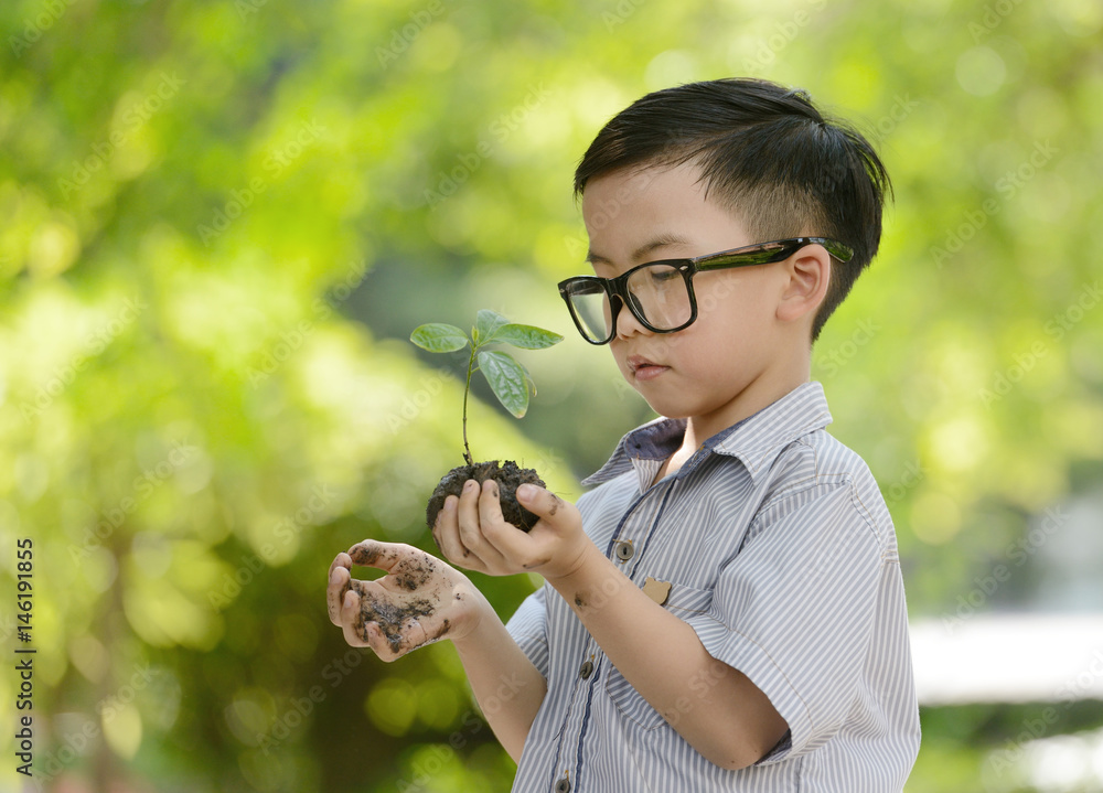 孩子抱着幼小的植物，希望有良好的环境