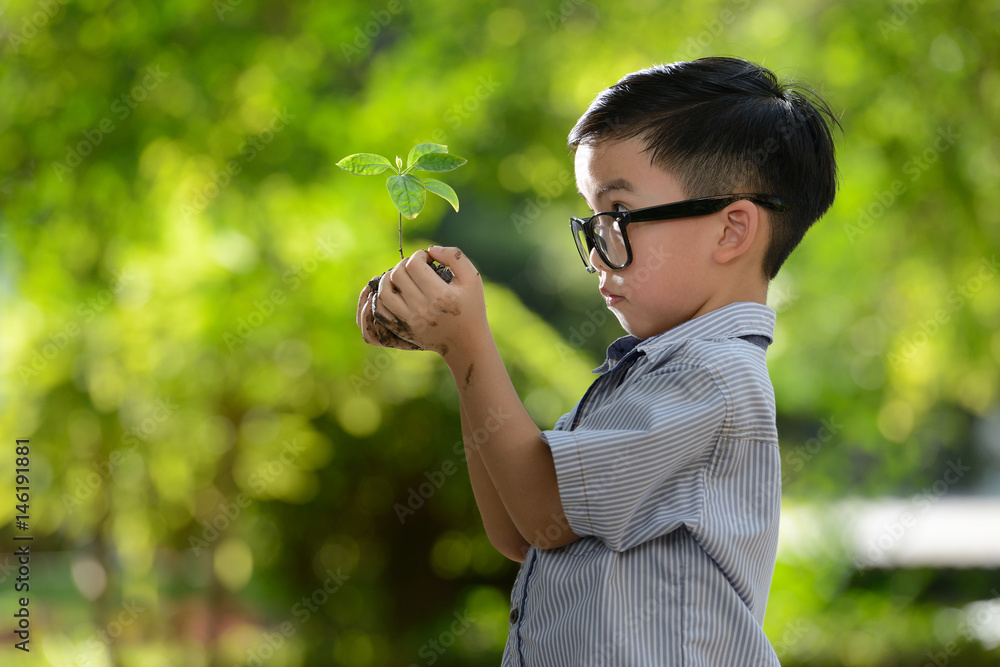 孩子抱着幼小的植物，希望有良好的环境