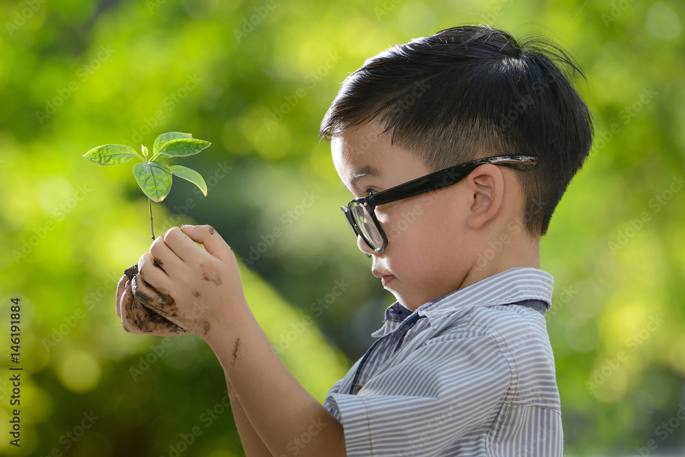 孩子抱着幼小的植物，希望有良好的环境