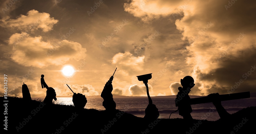 Silhouette hands holding tools at beach during sunset