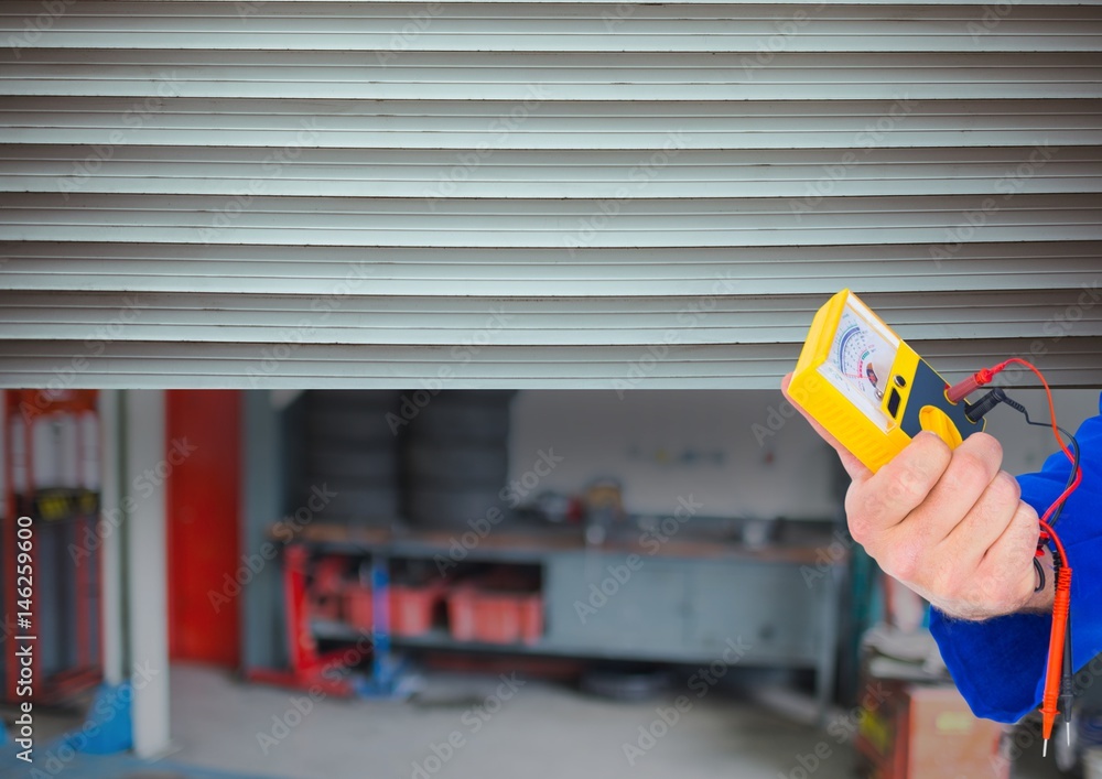 hand with tool in front of the garage