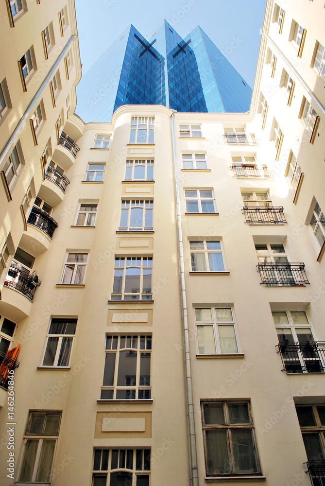 Tenement house on the background of a modern office building