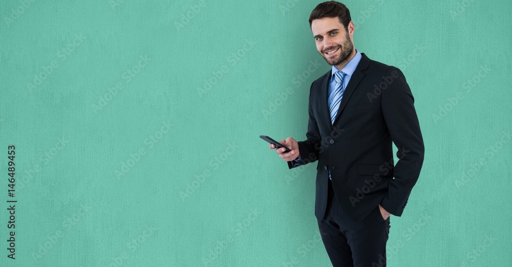 Confident businessman using mobile phone over green background